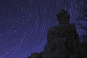 The cosmos spins and streaks behind a rock formation at Palisades State Park.
