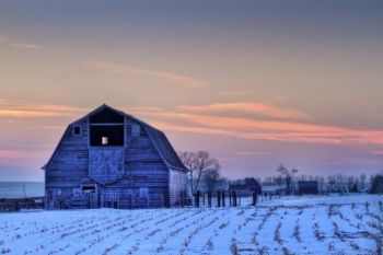 The last light of day colors the western sky with a pink hue behind this Moody County barn.