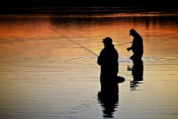 Fishermen silhouetted at sunset at Island Lake northeast of Montrose, SD.