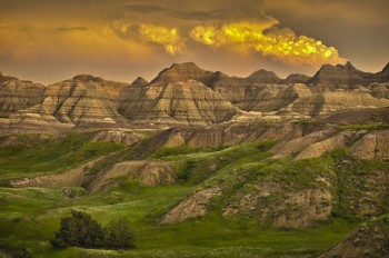 Badlands National Park glows in late evening light after a summer storm, giving the effect of a volcano erupting. Photo by Chad Coppess / S.D. Tourism.