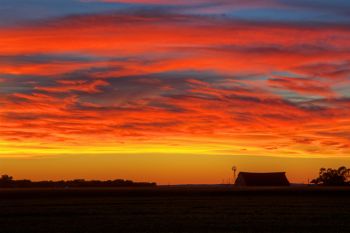 Brilliant sunset over a Bon Homme County barn and windmill.