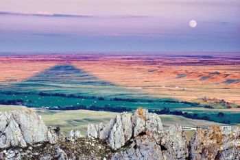 A full moon rises as Bear Butte casts a long shadow over an area crossed by Custer’s wagons on the morning of Aug. 16, 1874.
