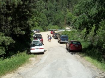 The road to Devil's Bathtub is crowded with parked cars.