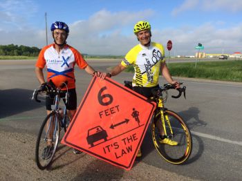 The author (left) and his legislative colleague Rep. Fred Deutsch took part in the Ride Across South Dakota (RASDAK). Their banner promotes South Dakota's new bicycling law.
