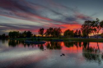 A colorful fall sunset reflected in Covell Lake in Sioux Falls.