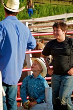 Young cowboys look up to a bareback rider just before the rodeo gets underway.
