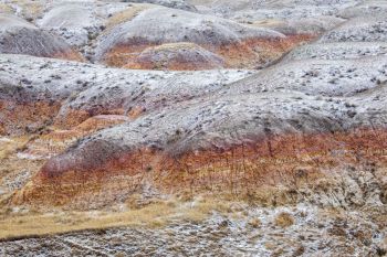 Yellow Mounds adorned with snow at Badlands National Park.