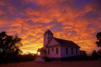 Academy United Church of Christ near the Bijou Hills as the setting sun continued to color the retreating storm clouds.