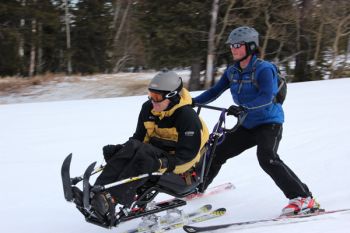 Bob Uecker, Sioux Falls, is guided by Nick Nolen, Rapid City, at Black Hills Ski for Light 2013.